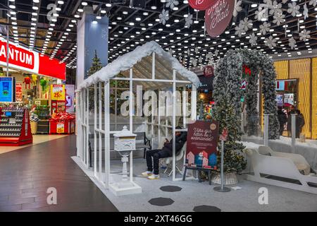 Wunderschöner Blick auf den Weihnachtsmarkt mit hängenden Schneeflocken, schneebedecktem Haus und Bänken zum Ausruhen. Festlich und einladend. Schweden Stockfoto