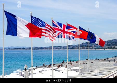 Flaggen der Europäischen Union, der USA, Großbritanniens, Frankreichs und der Schweiz am Mittelmeerstrand, der französischen Riviera, Cannes, Fahnenmasten am Strand Stockfoto