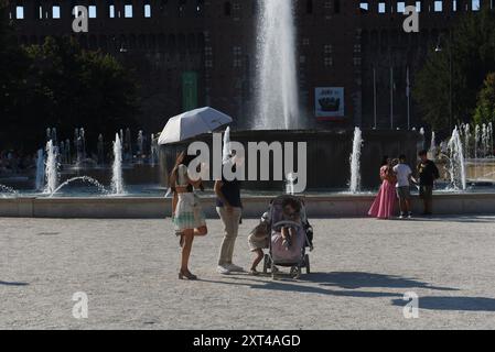 Mailand, Italien. August 2024. Die Menschen schützen sich mit Sonnenschirmen vor den Sonnenstrahlen vor dem Schloss Sforza. Die Hitzewelle, die Italien getroffen hat, hält an, mit Temperaturen von bis zu 41 Grad, die vor zwei Tagen in Florenz, in der Toskana, verzeichnet wurden. Die Situation sollte sich verbessern, sogar mit einem Rückgang der Mindesttemperaturen, ab dem Wochenende (Credit Image: © Ervin Shulku/ZUMA Press Wire) NUR REDAKTIONELLE VERWENDUNG! Nicht für kommerzielle ZWECKE! Stockfoto