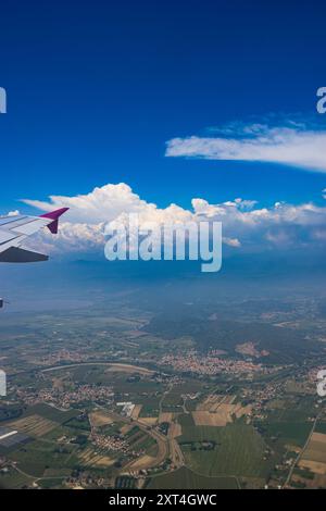 Luftaufnahme aus einem Flugzeugfenster. Flugzeugflügel und Stadtblick aus dem Flugzeug. Stockfoto