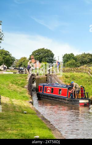 Menschen auf einem Kanalschmalboot, das durch Hurleston Schleusen am Llangollen Kanal bei Hurleston Cheshire England UK fährt Stockfoto