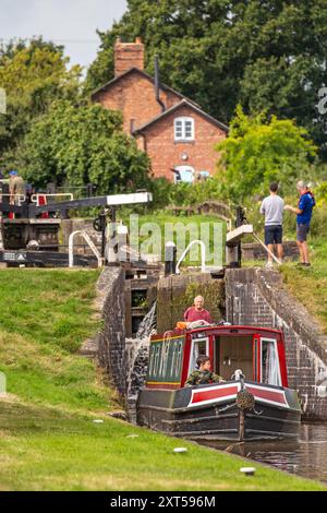 Menschen auf einem Kanalschmalboot, das durch Hurleston Schleusen am Llangollen Kanal bei Hurleston Cheshire England UK fährt Stockfoto