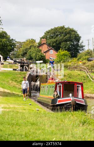 Menschen auf einem Kanalschmalboot, das durch Hurleston Schleusen am Llangollen Kanal bei Hurleston Cheshire England UK fährt Stockfoto