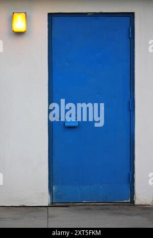 königsblaue Tür gegen eine helle Wand Stockfoto
