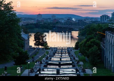 Ottawa, Kanada - 4. Juni 2024: Rideau-Kanalschleusen in Ottawa, Kanada. Blick auf Ottawa River, Alexandra Bridge und Gatineau Stadt Quebec bei Sonnenuntergang Stockfoto