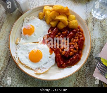 Komplettes englisches Frühstück mit Eiern, Würstchen, Bohnen und Pommes frites Stockfoto