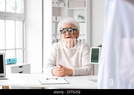 Seniorin mit Versuchsrahmen, die ihr Sehvermögen in der Klinik überprüft Stockfoto