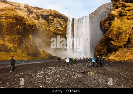 Nordischer Skgafoss-Wasserfall um März 2023, isländische Landschaft mit massiven Wasserläufen. Spektakulärer skandinavischer Fluss, der von gefrorenen Hügeln herunterfließt, Panoramablick. Stockfoto