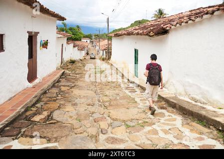 Guane, Santander, Kolumbien; 26. November 2022: Junger Mann, der von hinten gesehen wird, entspannte sich in dieser malerischen Kolonialstadt in einer Straße. Stockfoto