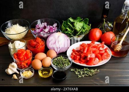 Zubereitete Auberginen-Parmigiana Shakshuka-Zutaten: Gehackte, gehackte und abgemessene Fusionsküche-Zutaten auf einem Holztisch Stockfoto
