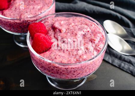 Gerichte von Himbeer-Chia-Pudding Nahaufnahme: Gesunde Frucht- und Chiasamen-Frühstückspudding garniert mit frischen Himbeeren Stockfoto