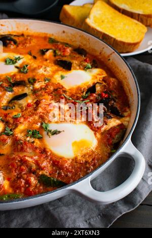 Shakshuka-Auberginen-Parmesan-Fusion-Küche mit Eiern in Tomaten, Spinat und Ricotta-Käse Stockfoto