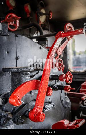 Nahaufnahme der roten Ventile und Steuermechanismen in einer Dampflokomotivkabine Stockfoto