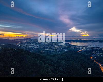 Blick aus der Luft Horizon Panorama Berg und dramatische Dämmerung Himmel und Wolken Sonnenaufgang Hintergrund. Funkelnde Lichter am Strand und in verschiedenen Städten Stockfoto