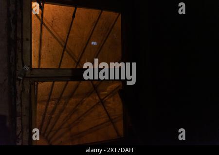 Ein Fenster im Keller des Hauses. Die gruselige Atmosphäre des Nachtkellers Stockfoto