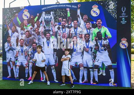 Die Fans von Real Madrid posieren für ein Foto vor dem Siegerteam der Champions League 2024. Die Fans der spanischen Champions-League-Gewinner Real Madrid und der italienischen UEFA-Cup-Gewinner Atalanta trafen sich auf dem Kahla-Platz in Warschau neben der Weichsel zum UEFA-Super-Cup-Fanfestival. Im Vorgriff auf das Spiel am folgenden Tag stehen die Besucher an, um Fotos mit der Trophäe zu machen und an einer Reihe von Fußballspielen und -Aktivitäten teilzunehmen. Der UEFA-Supercup findet am 14. August 2024 im PGE Narodowy in Warschau statt und wird von den Gewinnern der Champions League und des UEFA Cup wi bestritten Stockfoto