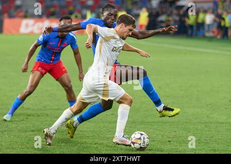 Bukarest, Rumänien. 13. August 2024: Joyskim Dawa von FCSB trifft Spartas Lukas Sadilek während der UEFA Champions League, dem dritten Qualifikationsrunde des 2. Legs zwischen FCSB und AC Sparta Praha, im Steaua Stadium in Bukarest. Quelle: Lucian Alecu/Alamy Live News Stockfoto