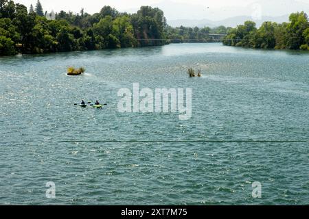 Redding, CA, USA. Juli 2024. Die Menschen schweben den Sacramento River in der Nähe der Sundial Bridge in der Turtle Bay in Redding, Kalifornien. Die Sundial Bridge ist eine weltberühmte Fußgängerbrücke und öffentliche Kunstinstallation, die den Sacramento River in Redding überquert und den Nord- und Südcampus des Turtle Bay Exploration Park verbindet. (Kreditbild: © Marty Bicek/ZUMA Press Wire) NUR REDAKTIONELLE VERWENDUNG! Nicht für kommerzielle ZWECKE! Stockfoto