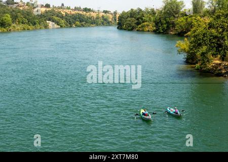 Redding, CA, USA. Juli 2024. Die Menschen schweben den Sacramento River in der Nähe der Sundial Bridge in der Turtle Bay in Redding, Kalifornien. Die Sundial Bridge ist eine weltberühmte Fußgängerbrücke und öffentliche Kunstinstallation, die den Sacramento River in Redding überquert und den Nord- und Südcampus des Turtle Bay Exploration Park verbindet. (Kreditbild: © Marty Bicek/ZUMA Press Wire) NUR REDAKTIONELLE VERWENDUNG! Nicht für kommerzielle ZWECKE! Stockfoto
