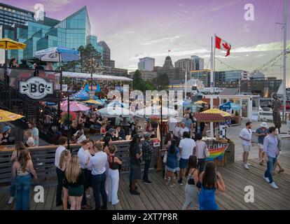 Halifax Beer Garden (The BG) in Halifax, Nova Scotia, Kanada. An einem Sommersamstagabend warten Leute darauf, das Open-Air-Restaurant und die Bar am Wasser zu betreten. Stockfoto