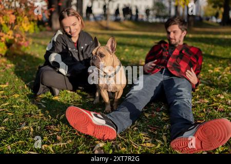 Paare und ihr Hund haben eine tolle Zeit im Park während der farbenfrohen Herbstsaison Stockfoto