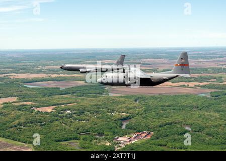 Eine 182. Luftbrücke C-130H Hercules und ein 126. Luftbetankungsflügel KC-135R Stratotanker fliegen eine Formation über den 183. Flügel in Springfiel Stockfoto