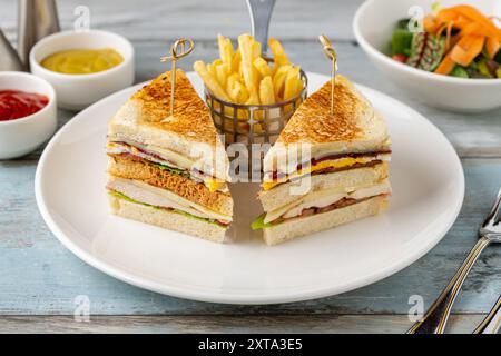 Chicken Club Sandwich mit Pommes, Ketchup, Senf und Mayonnaise Stockfoto