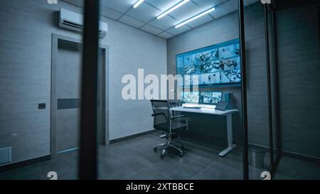 Blick auf den Arbeitsplatz für Überwachungspersonal oder Disposition in einem dunklen, modernen Überwachungsraum. CCTV-Videomaterial von Überwachungskameras im Büro auf Computermonitoren, Tablet-Display und großem Digitalbildschirm. Stockfoto