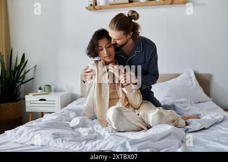 Ein liebevolles Paar kuschelt sich an einem Bett und genießt einen entspannenden Moment zusammen. Stockfoto