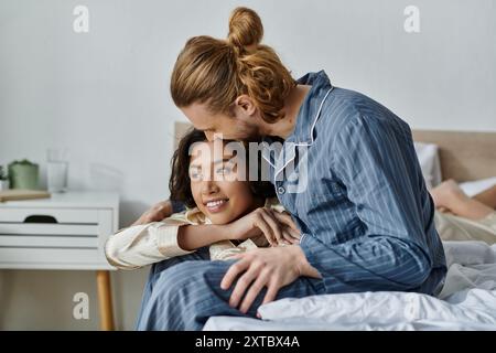 Ein liebevolles Paar kuschelt sich im Bett und teilt einen zarten Moment. Stockfoto