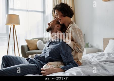 Ein liebevolles Paar entspannt sich in ihrem Schlafzimmer und teilt eine zärtliche Umarmung. Stockfoto