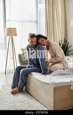 Ein Paar entspannt sich auf einem Bett in einem hellen Schlafzimmer und genießt einen Moment der Intimität. Stockfoto