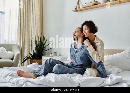 Ein liebevolles Paar im Pyjama entspannt sich auf einem Bett in einem gemütlichen Schlafzimmer. Stockfoto