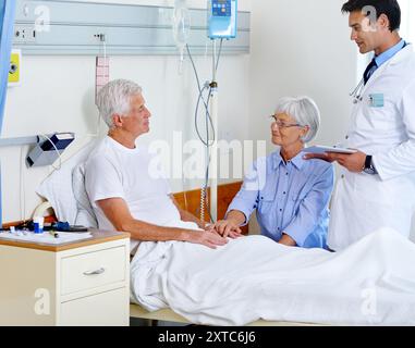 Patient, Arzt und Frau im Bett im Krankenhaus, Arzt und Diagnose mit Tablette für Senioren. Menschen, Unterstützung und Liebe für den Besuch von OR Stockfoto