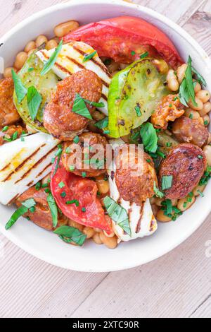 In der Pfanne gekochte Bohnen- und Chorizo-Gerichte mit frischem Gemüse und Weichkäse. Stockfoto