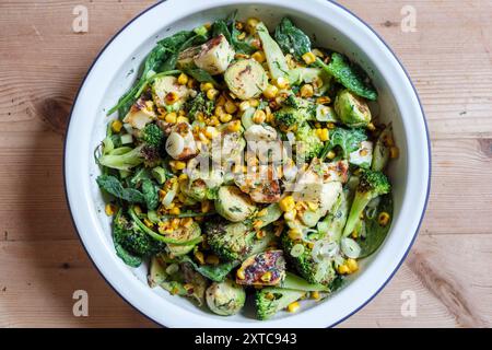 Ein verkohltes frisches Gemüsegericht mit rosenkohl, gegrilltem Käse, Brokkoli-Stielen, Zuckermais, zerstoßenen Nüssen und Dressing. Stockfoto