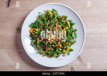 Ein großes rohes Gemüsesalat mit Grünkohl, Karotten, Mandeln, getrockneten Carnbeeren und Granatapfel. Stockfoto