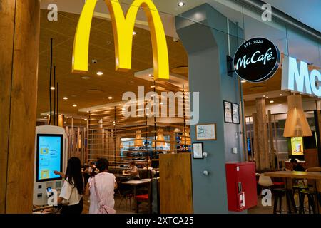 Innenblick auf McDonald's Restaurant mit zeitgenössischer Holzeinrichtung. Modernes Fast-Food-Restaurant mit Selbstbedienungskiosken. Kopenhagen, Denmar Stockfoto