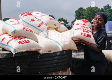 Die Weibchen in Abuja kämpfen in einer lokalen Maniok-Verarbeitungsfabrik unter schwierigen Bedingungen, um Mehl herzustellen, während sie die Spreu aus fermentiertem Maniok waschen. Angesichts der wirtschaftlichen Unsicherheiten stehen diese jungen Mädchen und Frauen vor verschiedenen Herausforderungen, um sich selbst zu stärken, Arbeitsplätze für andere zu schaffen und den Lebensunterhalt zu sichern. Die meisten Frauen hier sind Brotgewinner und sie kämpfen für ihre Familien. Nigeria. Stockfoto