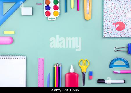 Ein Studentenpaket. Das Layout der Schulmaterialien auf dem Tisch, Rahmen der Materialien von oben Ansicht Nerzgrüner Hintergrund. Kopierbereich für Text. Zurück zur Schule, von Stockfoto