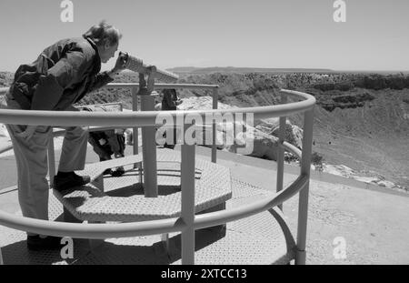 Der 50-60-jährige Kaukasier blickt auf den beeindruckenden Meteor-Krater entlang der Route 66 bei Winslow, AZ. USA Stockfoto