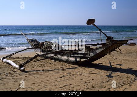 Traditionelles Holzfischboot mit Outtrider am Bentota Beach in der Nähe von Bentota, Südprovinz, Sri Lanka. Archivbild, das 2001 aufgenommen wurde Stockfoto