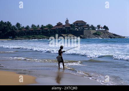 Man fischt am Bentota Beach, mit Saman Villas im Hintergrund, in der Nähe von Bentota, Südprovinz, Sri Lanka. Archivbild, das 2001 aufgenommen wurde Stockfoto