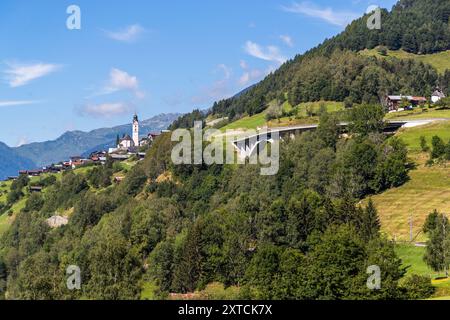 Landschaft in Graubünden mit Wald, Bergen und dem Dorf Disentis auf der nostalgischen Bahnfahrt von Davos nach Andermatt mit dem Glacier Pullman Express. Via Marias, Trun, Rabius, Graubünden, Schweiz Stockfoto