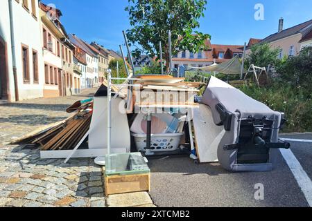 Ein Haufen aussortierter Haushaltsgegenstände und Möbel, die auf einer kopfsteingepflasterten Straße aufgehäuft sind und einen Tag der Müllsammlung in einer Stadt darstellen Stockfoto