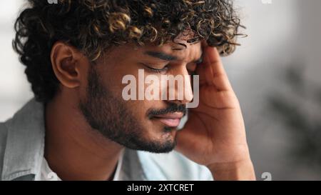 Nahaufnahme Porträt eines müden, verärgerten, traurigen Indianers, der die Nasenbrücke reibt. Millennials-indischer Student berührt das Gesicht, will schlafen, fühlt Spannung Stockfoto