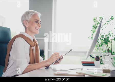 Foto von smarten älteren Chefin weiblichen Job Interview Video Anruf Kleidung formalwear komfortable moderne Büro Loft Raum innen Arbeitsplatz Stockfoto