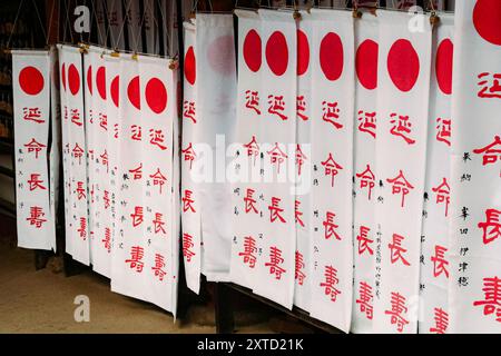 Nara, Japan - 5. März 2018 - religiöse Banner mit roten Kreisen und japanischen Schriftzeichen am Kasuga Taisha Schrein Stockfoto