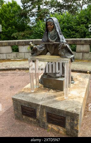 Statue der Heiligen Therese von Lisieux. Statue der Heiligen Therese mit einem Kreuz in der Hand in der Basilika Lisieux, Frankreich Stockfoto