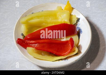 Gehackte gelbe und rote Paprika auf einem Teller. Stockfoto